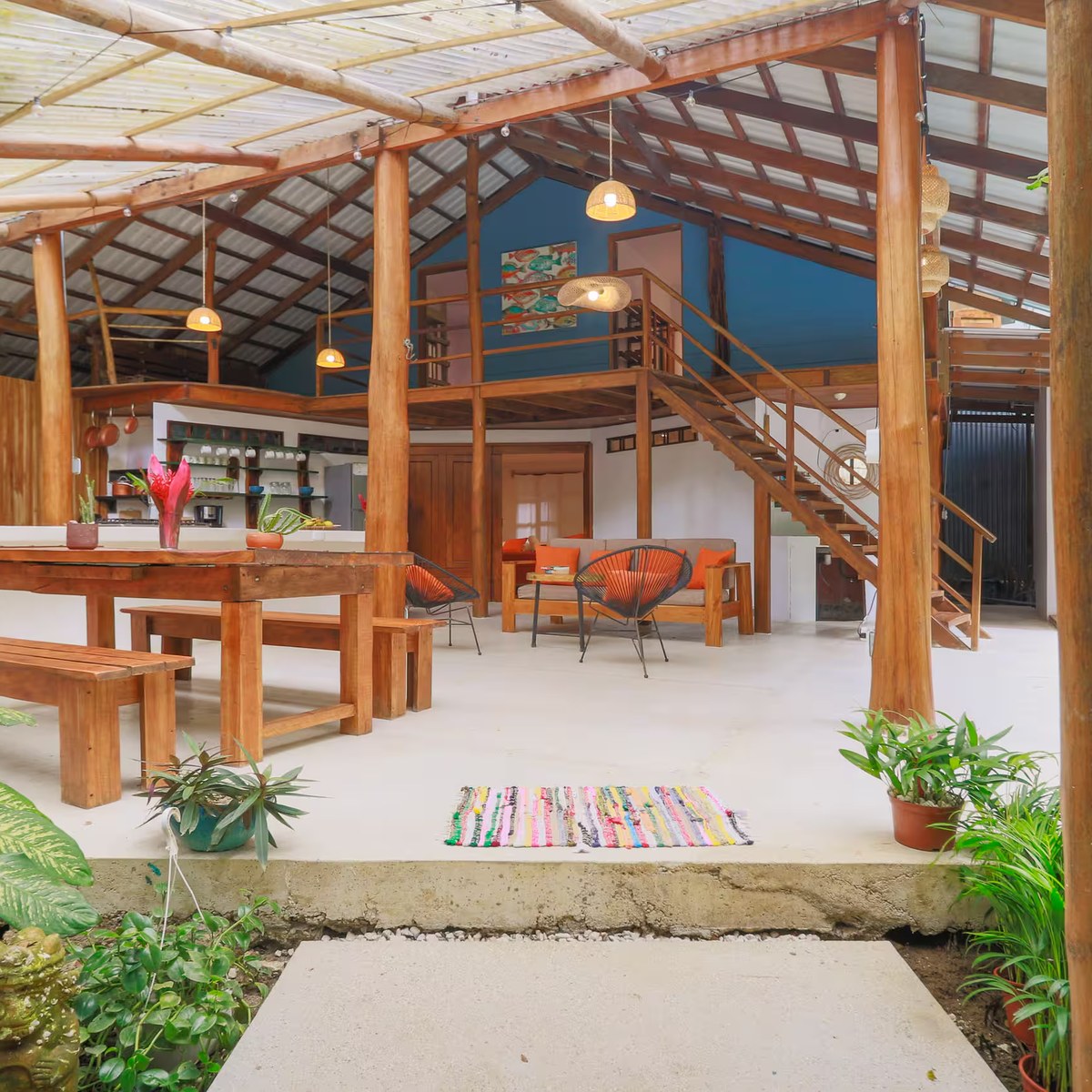 The open-air living space, looking out through planting to the pool